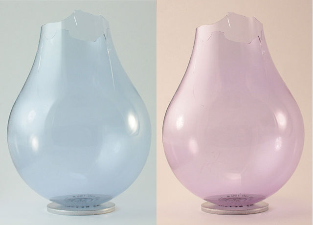 File:Neodymium glass light bulb under fluorescent and incandescent light.jpg