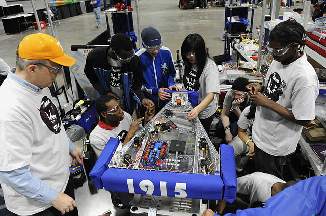 File:US Navy 100305-N-7676W-182 Cmdr. Jim Grove, from the Office of Naval Research Navy Reserve Program 38, left, helps tudents from McKinley Technology High School make adjustments to their robot.jpg